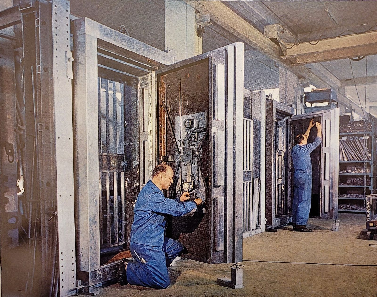 Two fitters at work on large bank vault doors